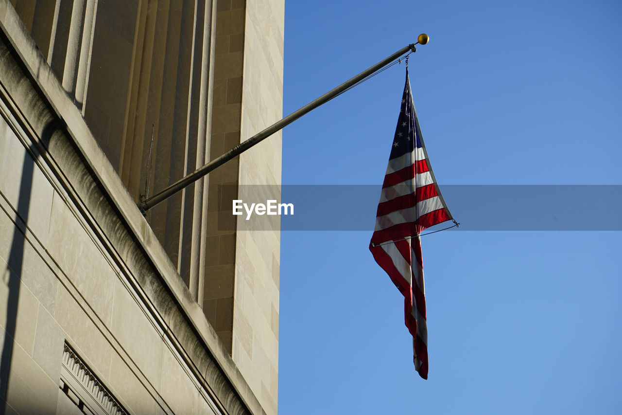 patriotism, flag, architecture, sky, low angle view, blue, building exterior, built structure, clear sky, no people, nature, striped, day, city, building, outdoors, wind, office building exterior, independence, sunny, pole