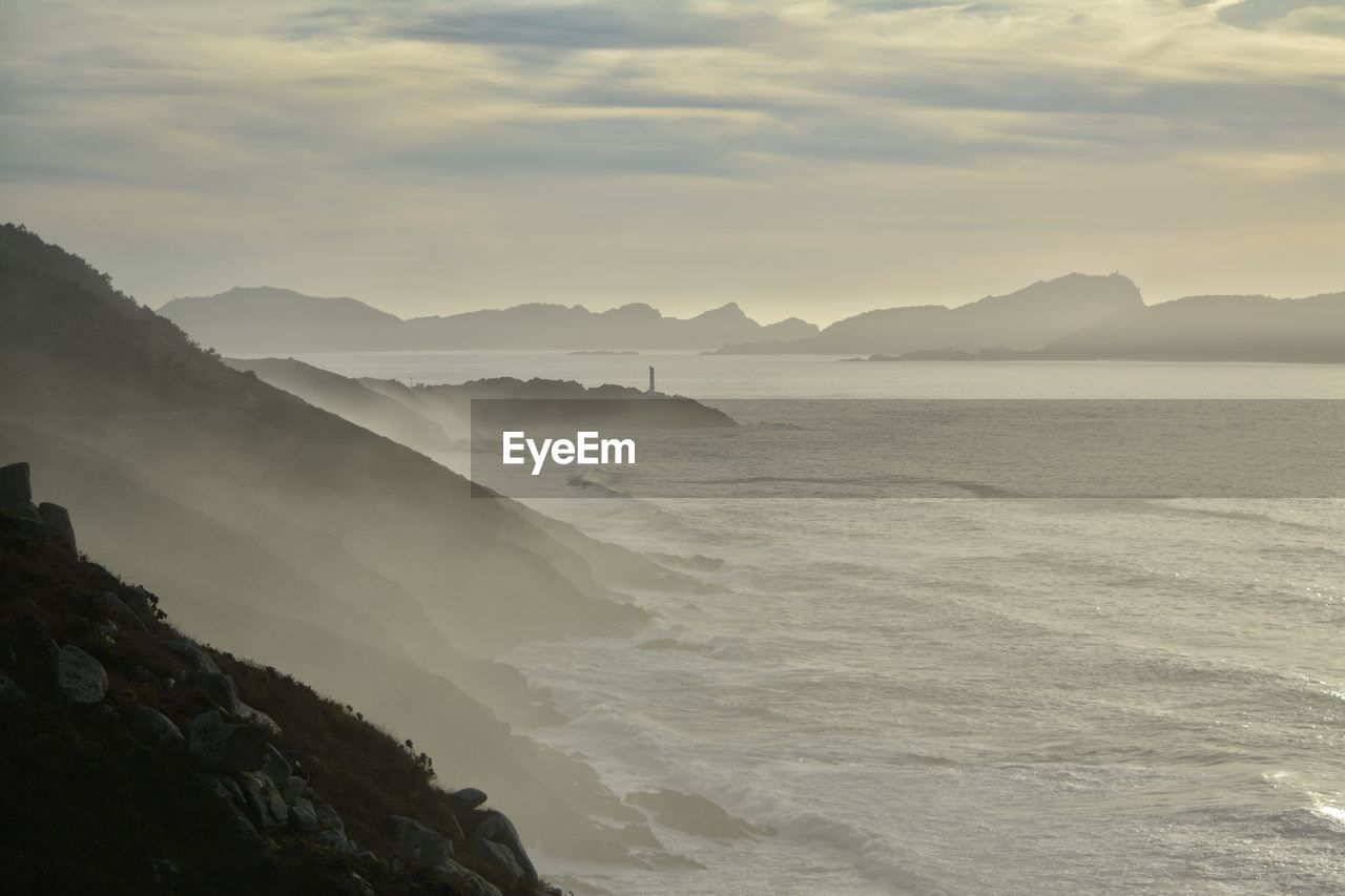 Scenic view of sea and mountains against sky