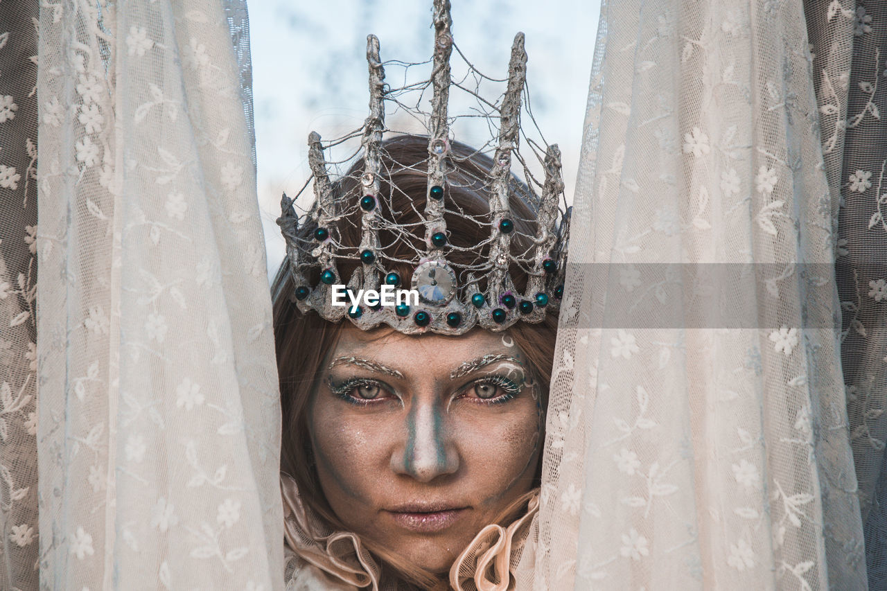 Close-up of woman with face paint wearing headwear