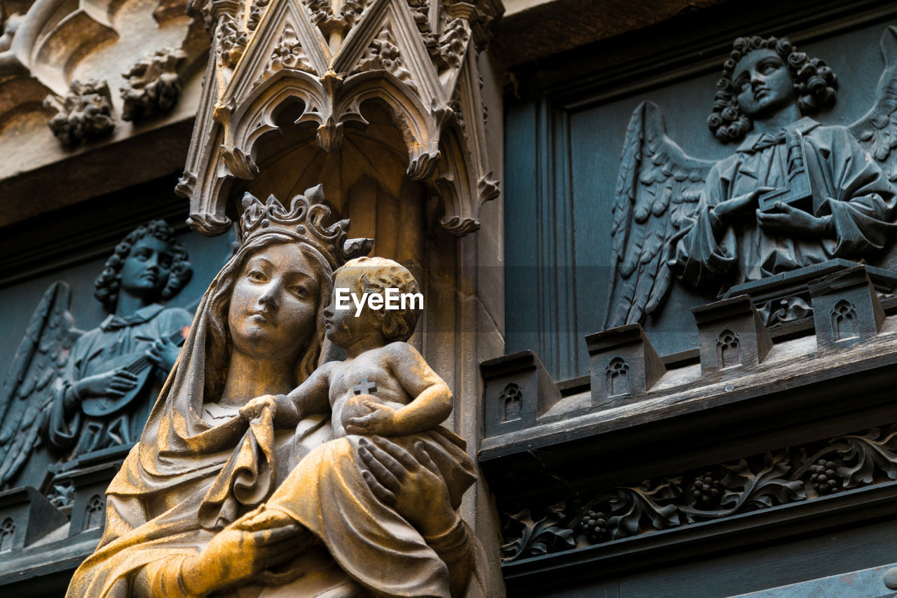 LOW ANGLE VIEW OF ANGEL STATUE AGAINST BUILDING