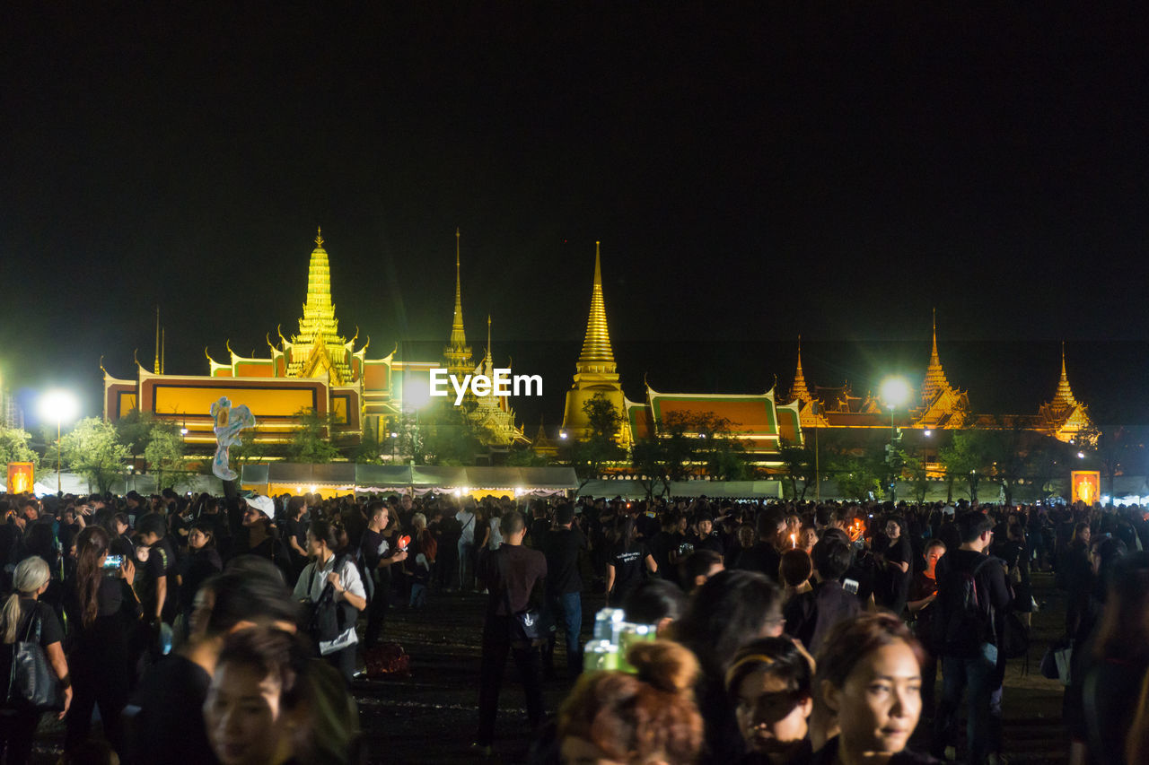 CROWD AT ILLUMINATED TEMPLE AGAINST SKY
