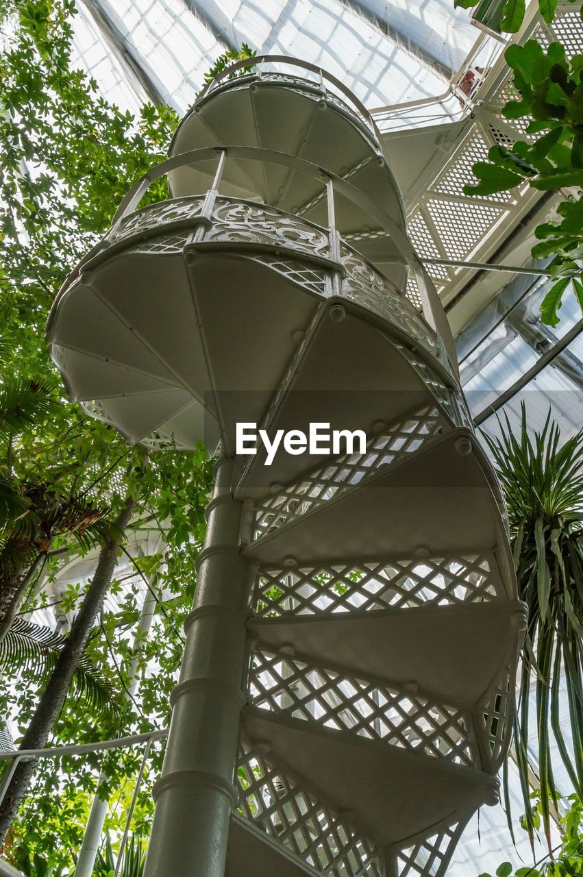 Low angle view of white spiral staircase in greenhouse
