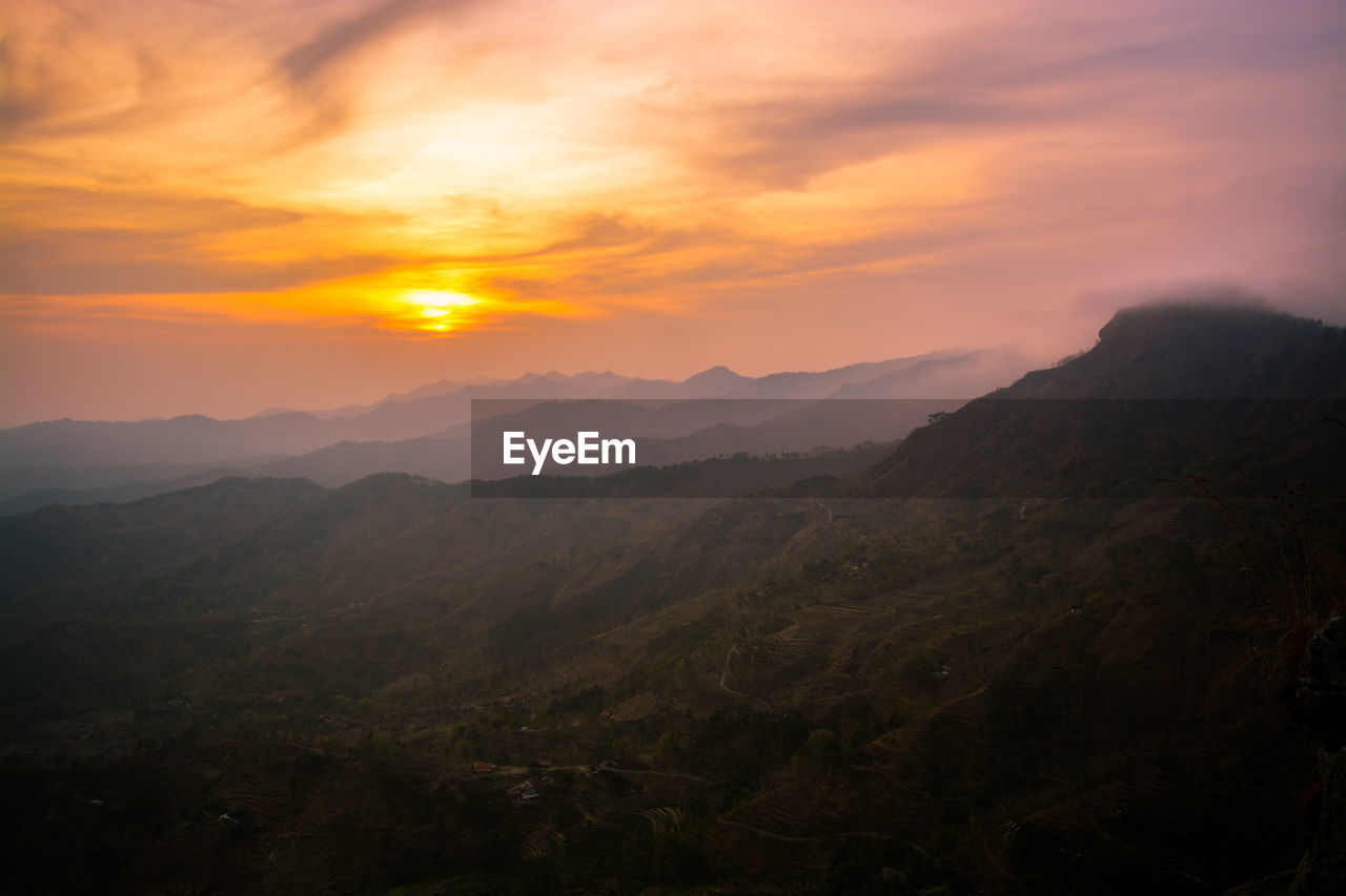 Scenic view of mountains against orange sky