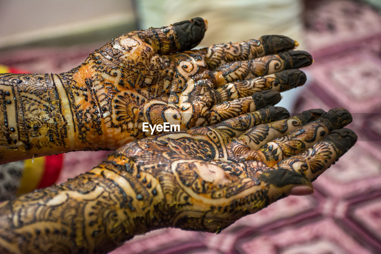 Cropped hands of woman with henna tattoo