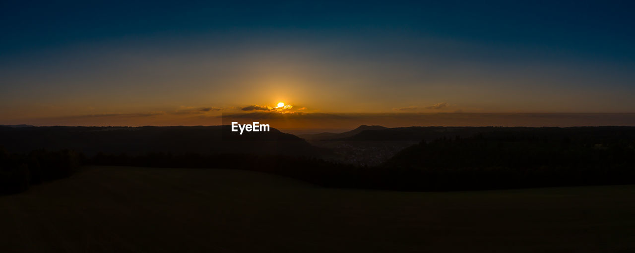 Scenic view of silhouette mountains against sky during sunset