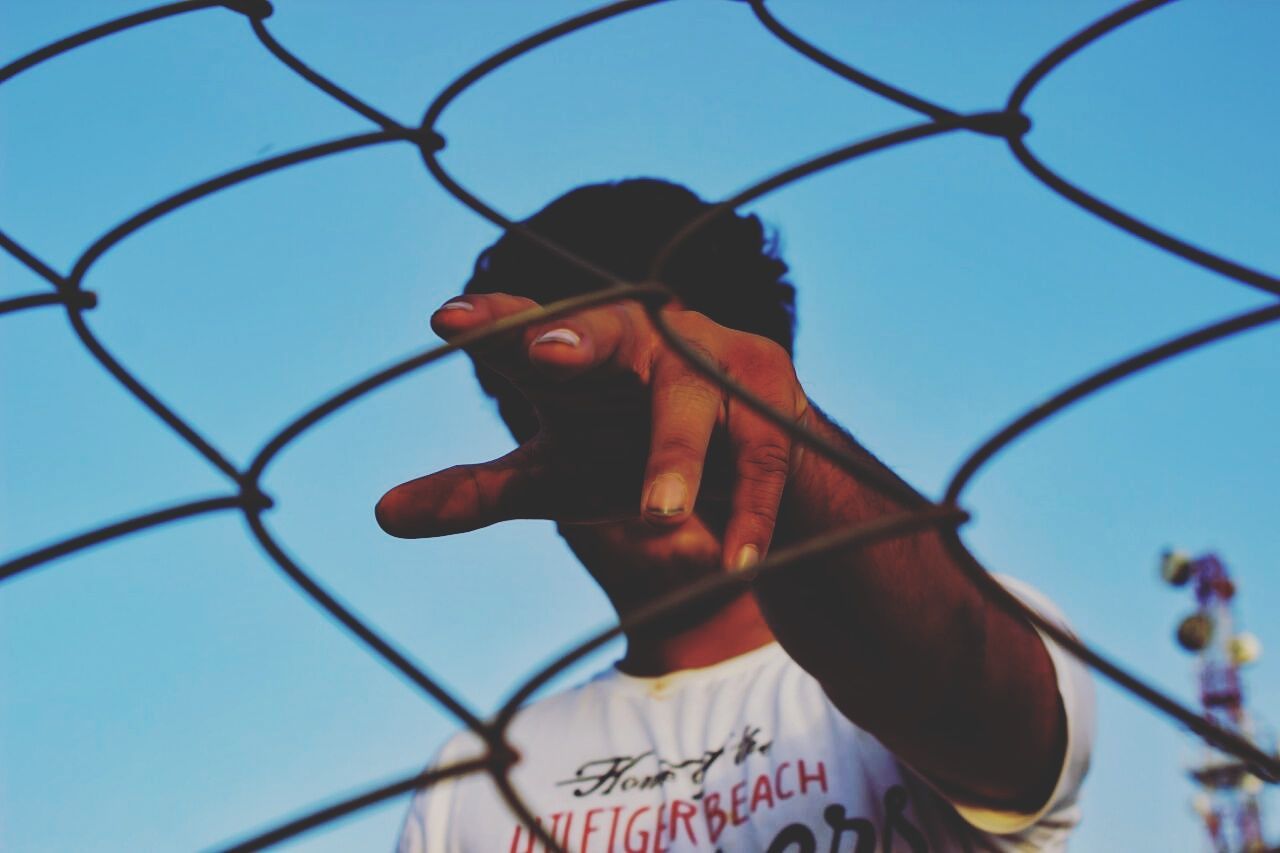 LOW ANGLE VIEW OF CHAINLINK FENCE AGAINST CLEAR SKY