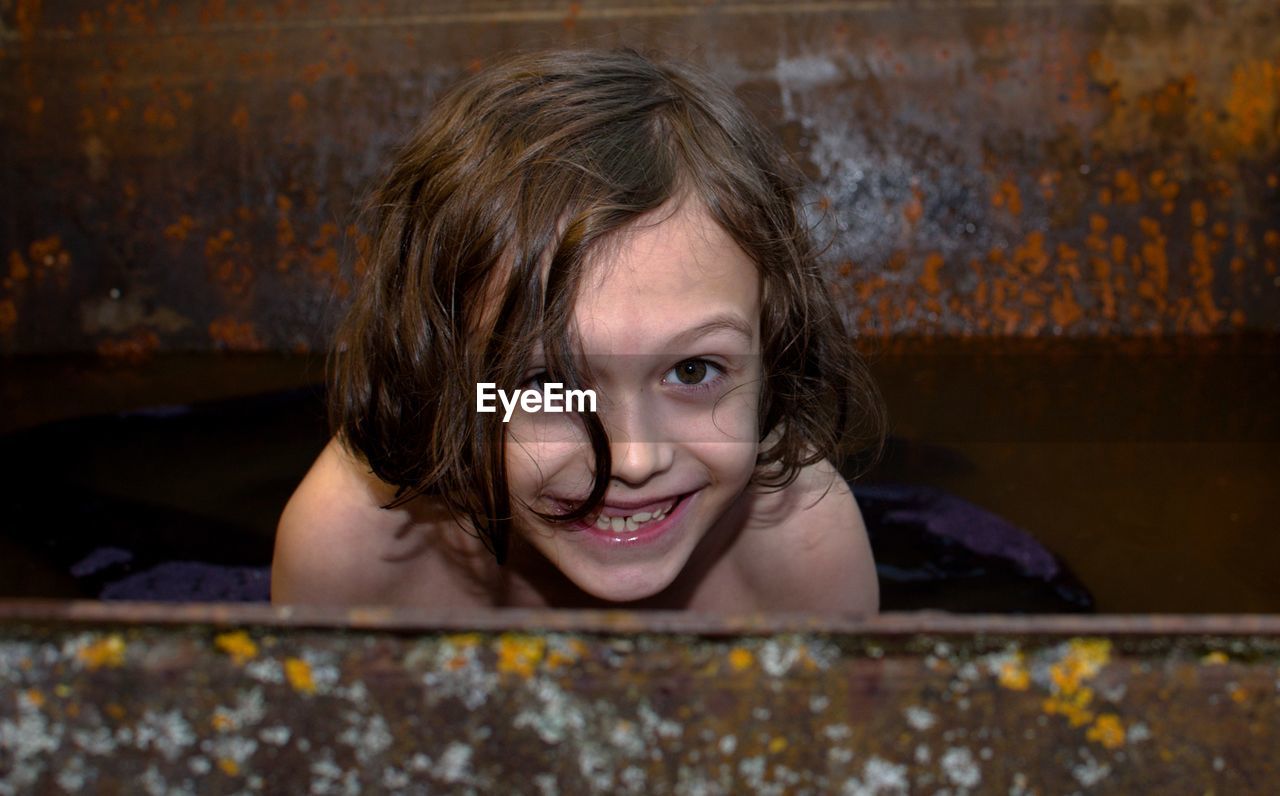 Portrait of smiling girl in metallic container