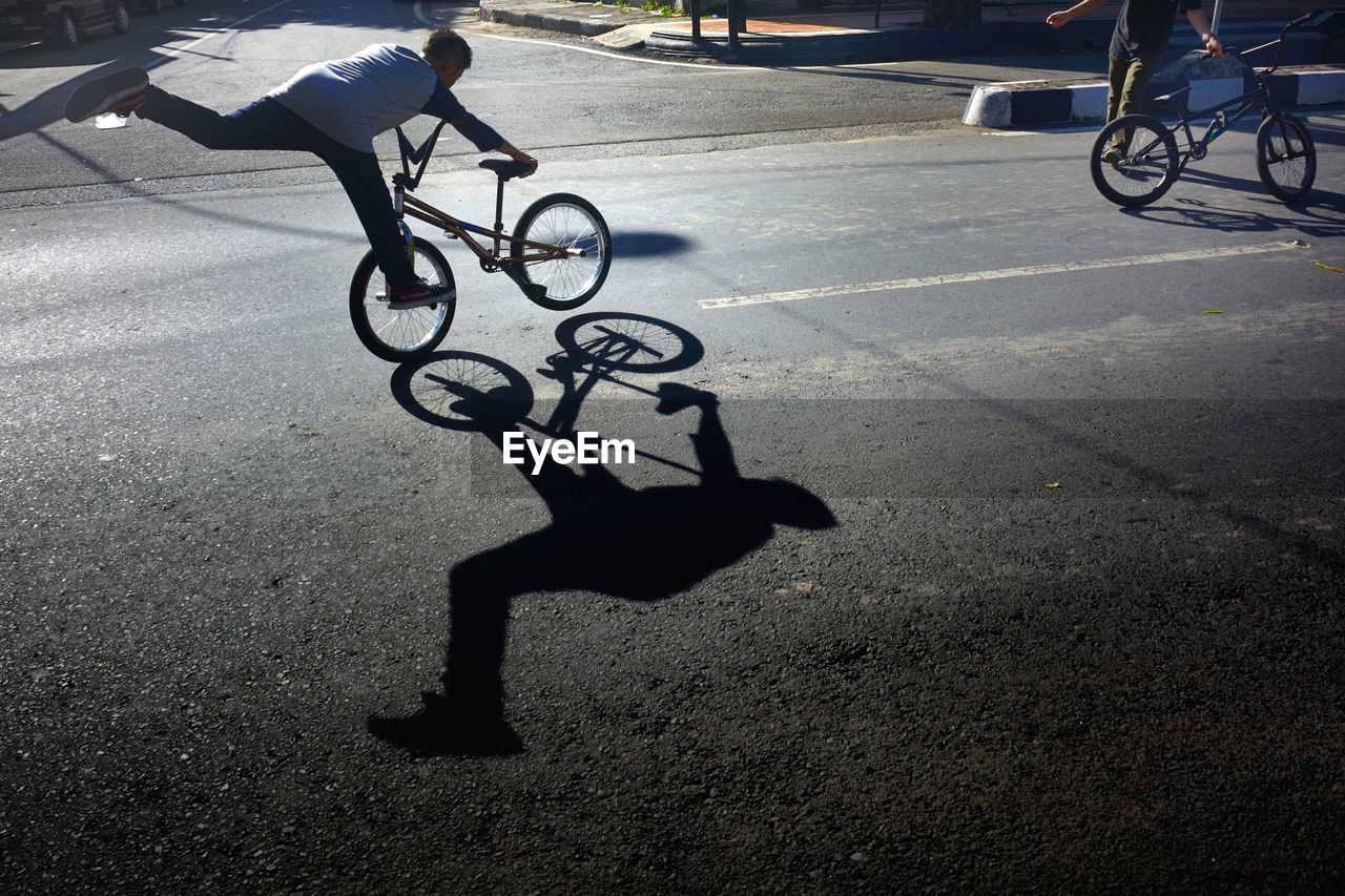 Friends performing stunts on bicycles