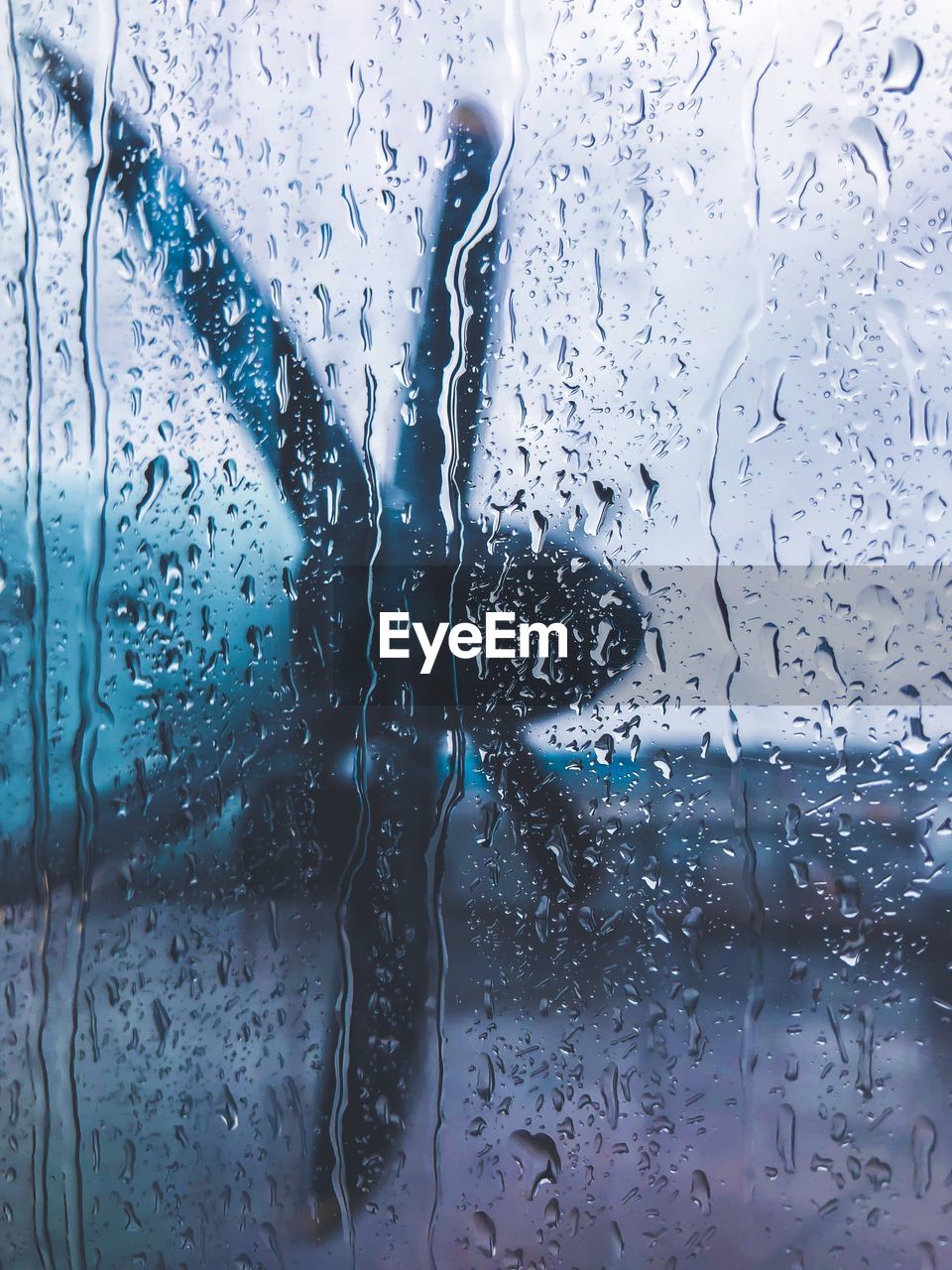 CLOSE-UP OF RAINDROPS ON GLASS WINDOW