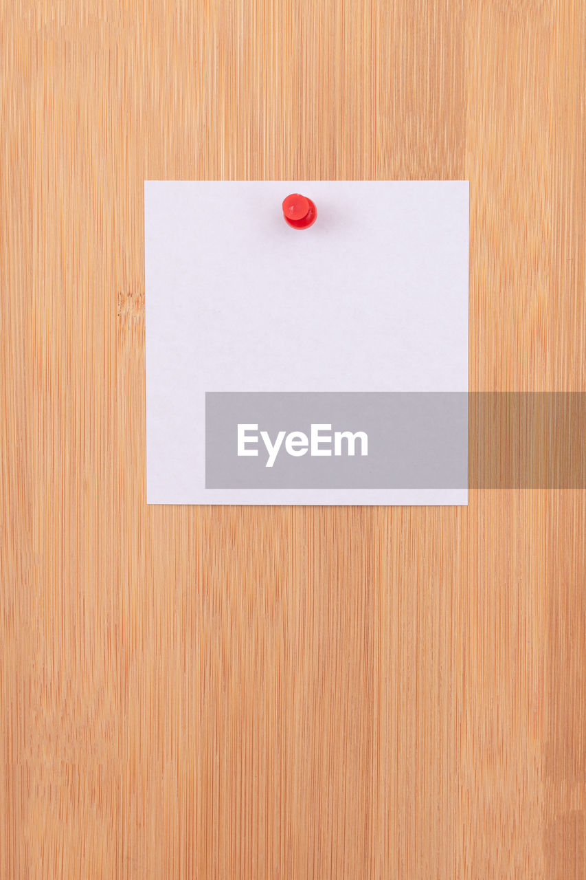 CLOSE-UP OF WHITE PAPER ON WOOD