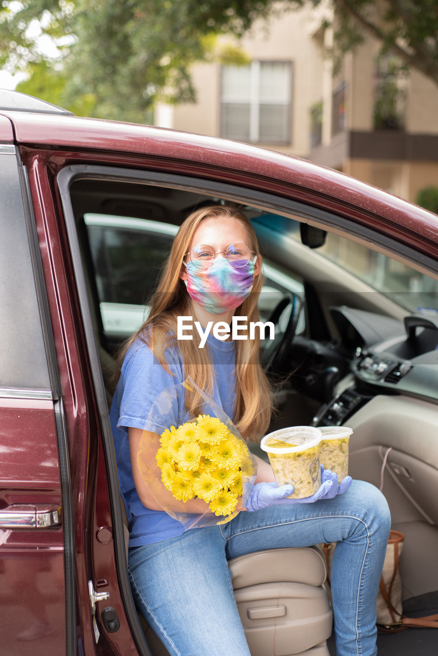 Woman with flowers in car