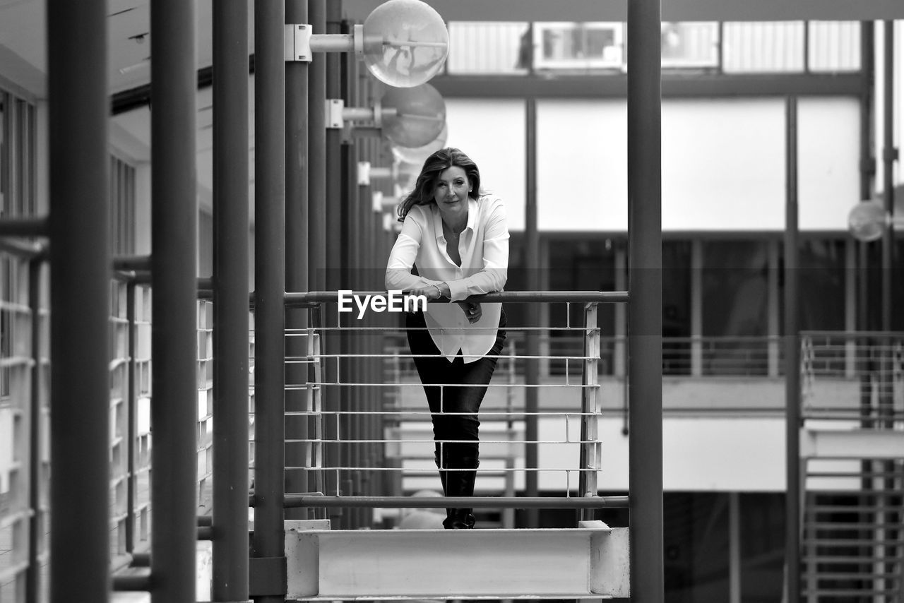 Side view of young woman standing against wall