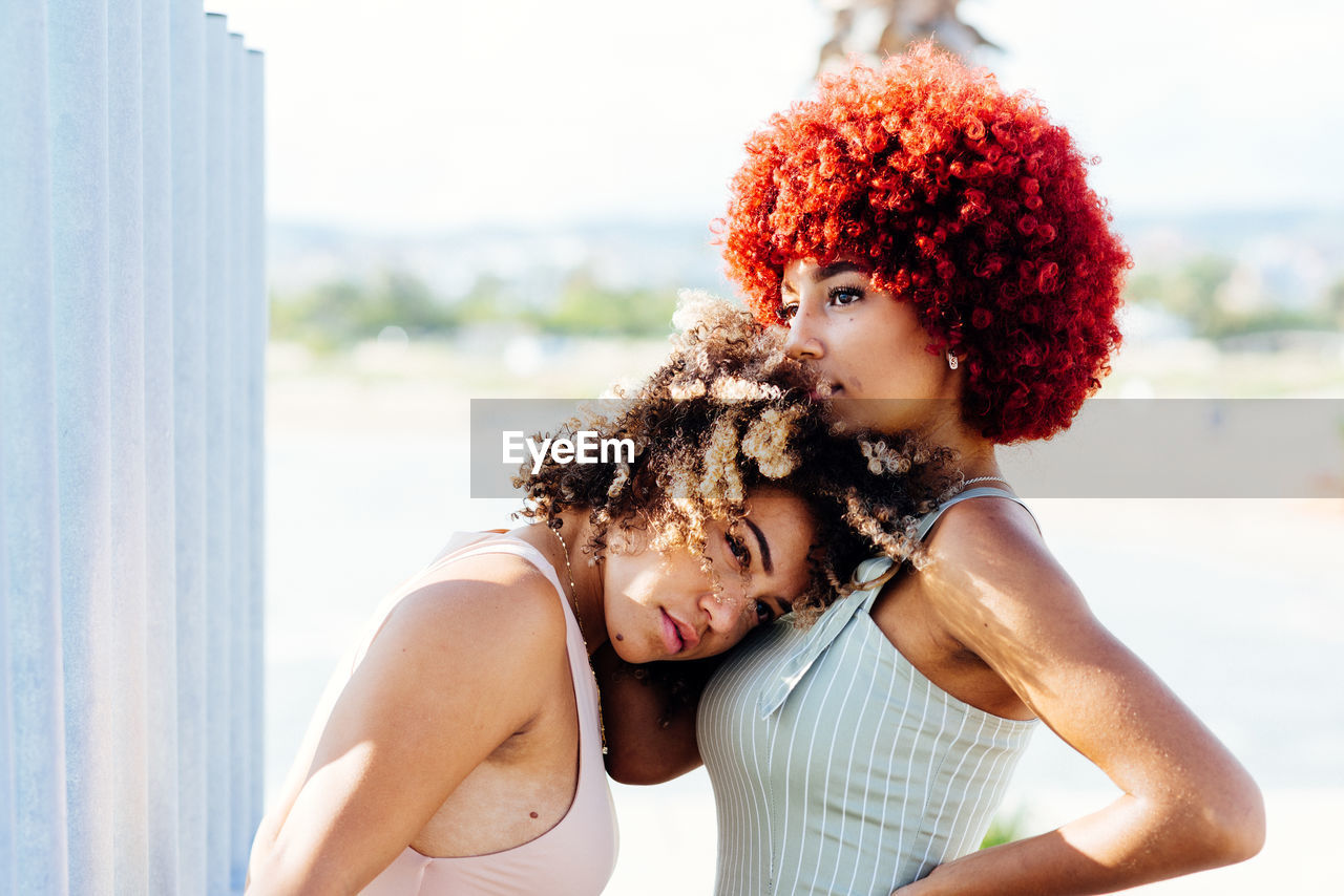 Two attractive latin girls with afro hair in an attitude of love.