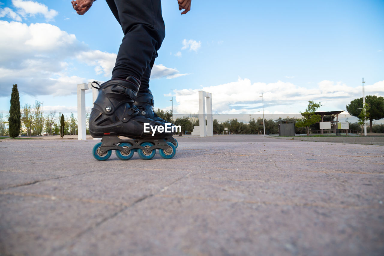 Low section of man skating on road