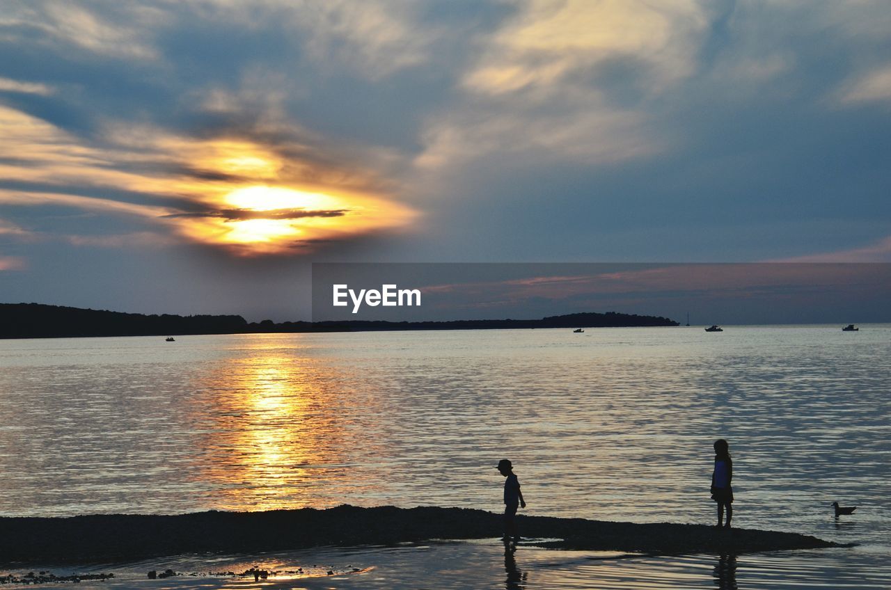 Scenic view of sea against cloudy sky during sunset