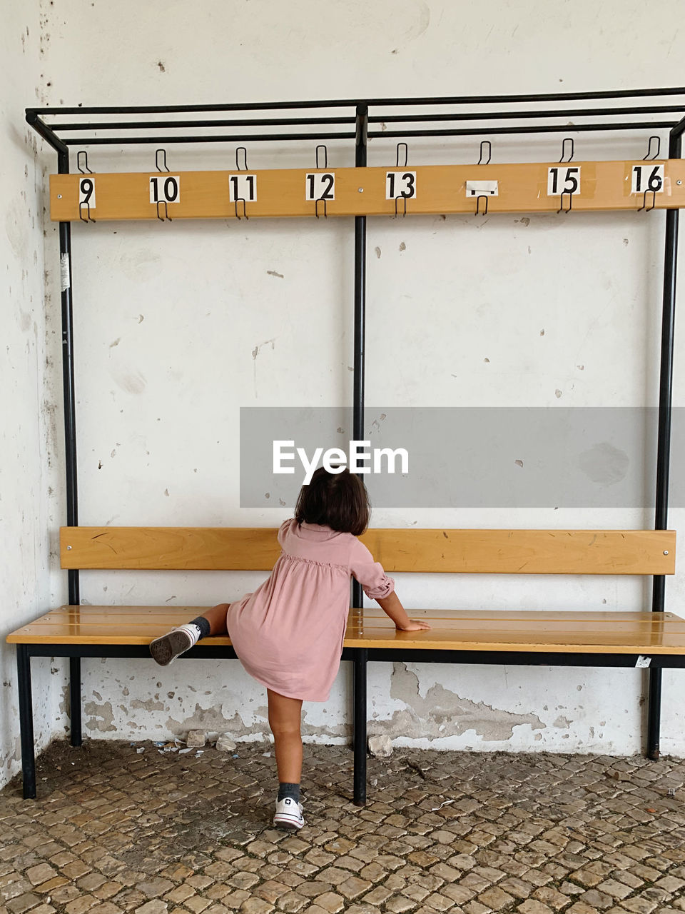 Rear view of girl climbing a bench 