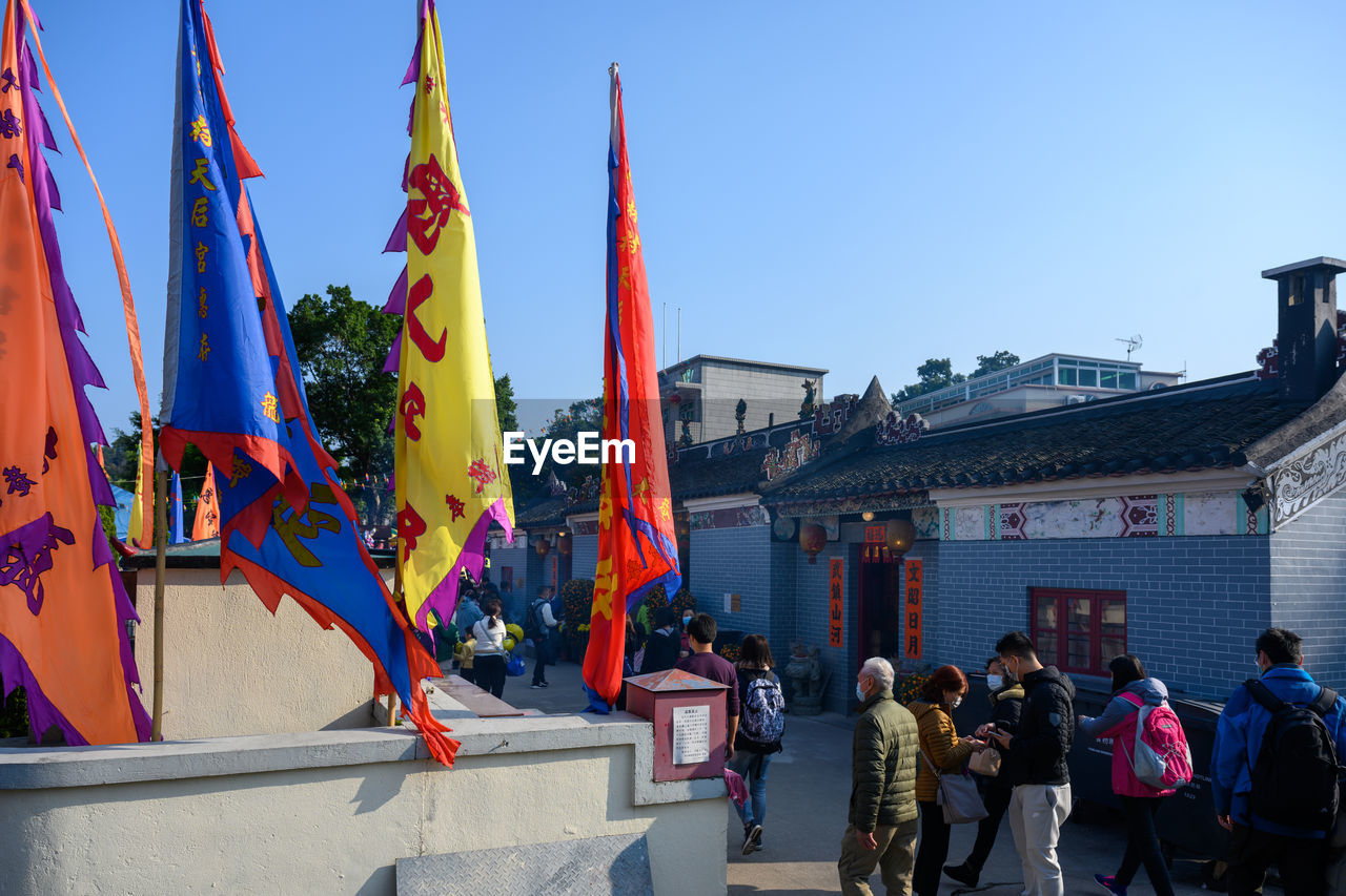 GROUP OF PEOPLE AGAINST BUILDINGS AGAINST SKY