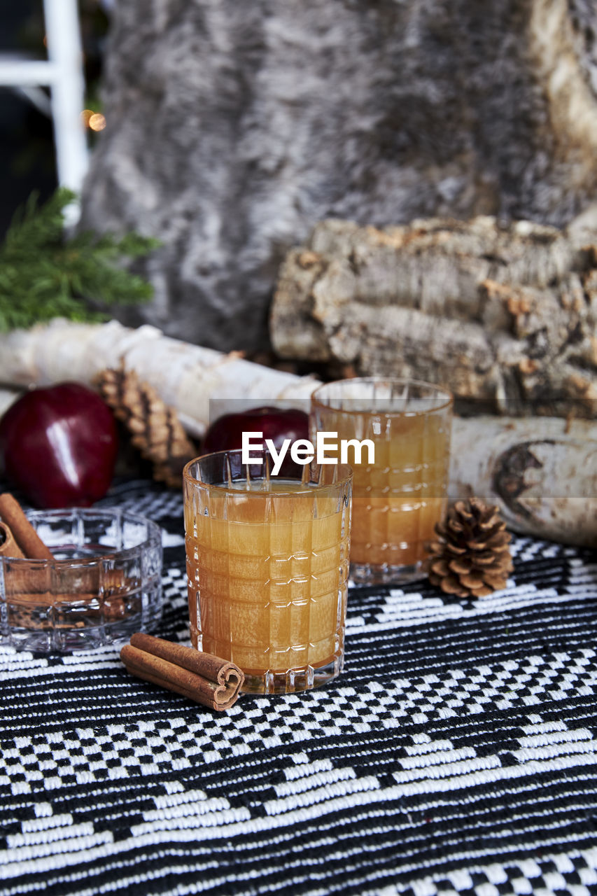 Apple spiced cider served on ice with apple and cinnamon