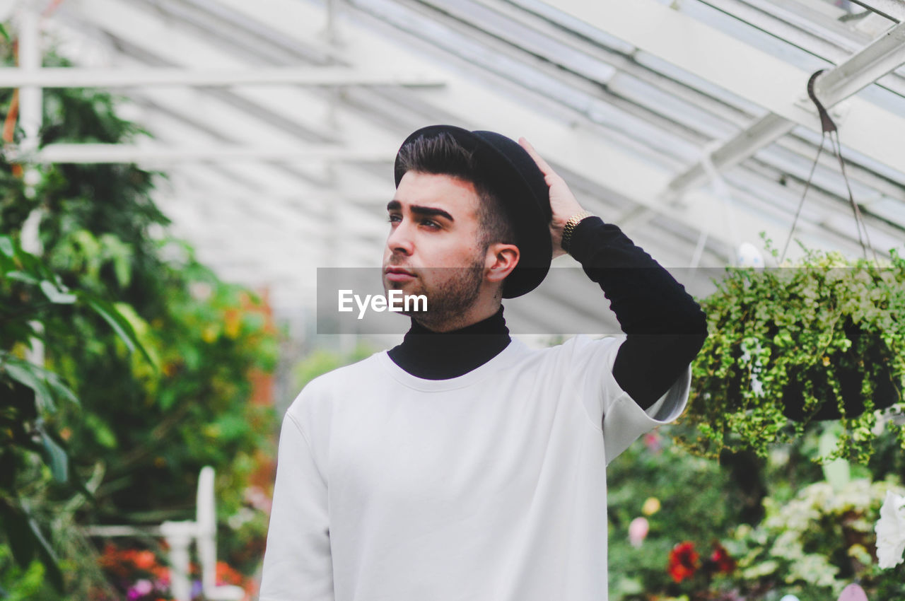 THOUGHTFUL MAN IN GREENHOUSE