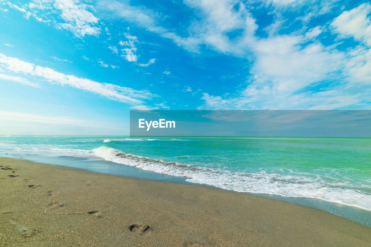 SCENIC VIEW OF BEACH AGAINST BLUE SKY