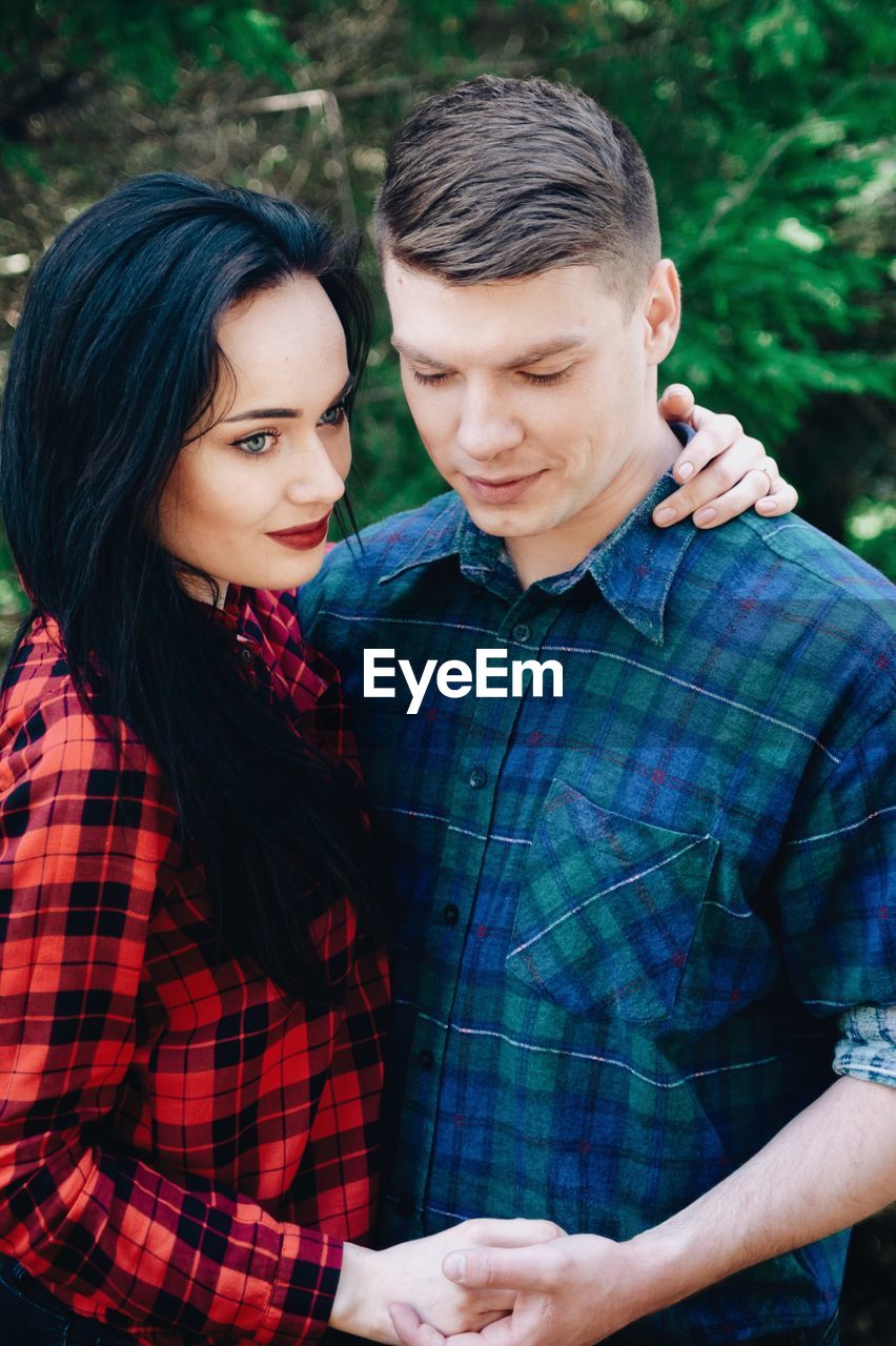 Loving young couple standing in forest