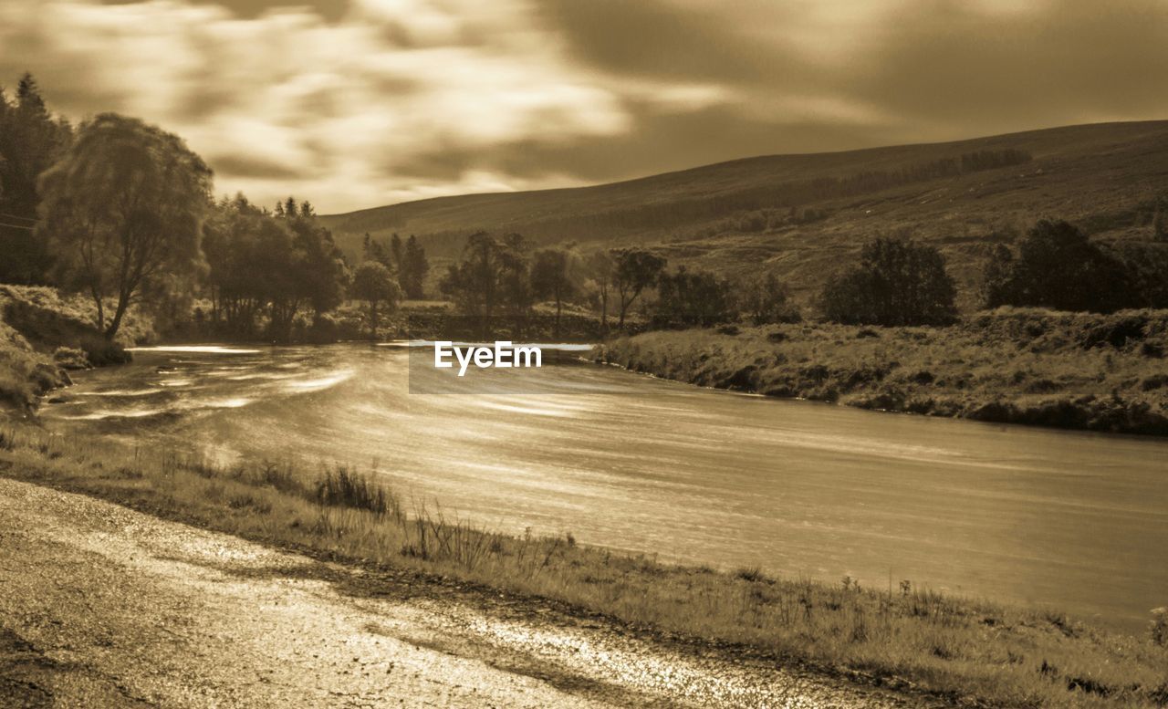 Tranquil view of river against mountains and sky