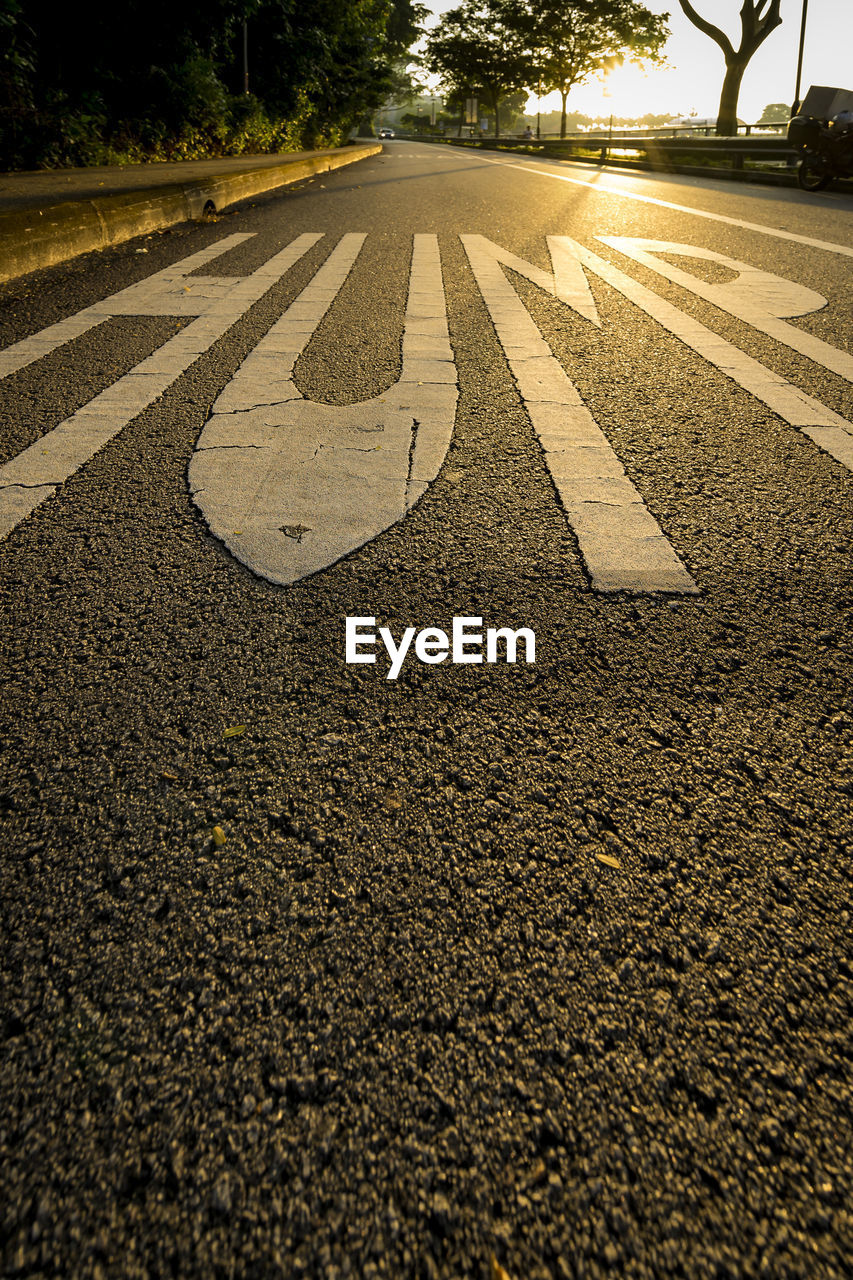 Text on empty road during sunset