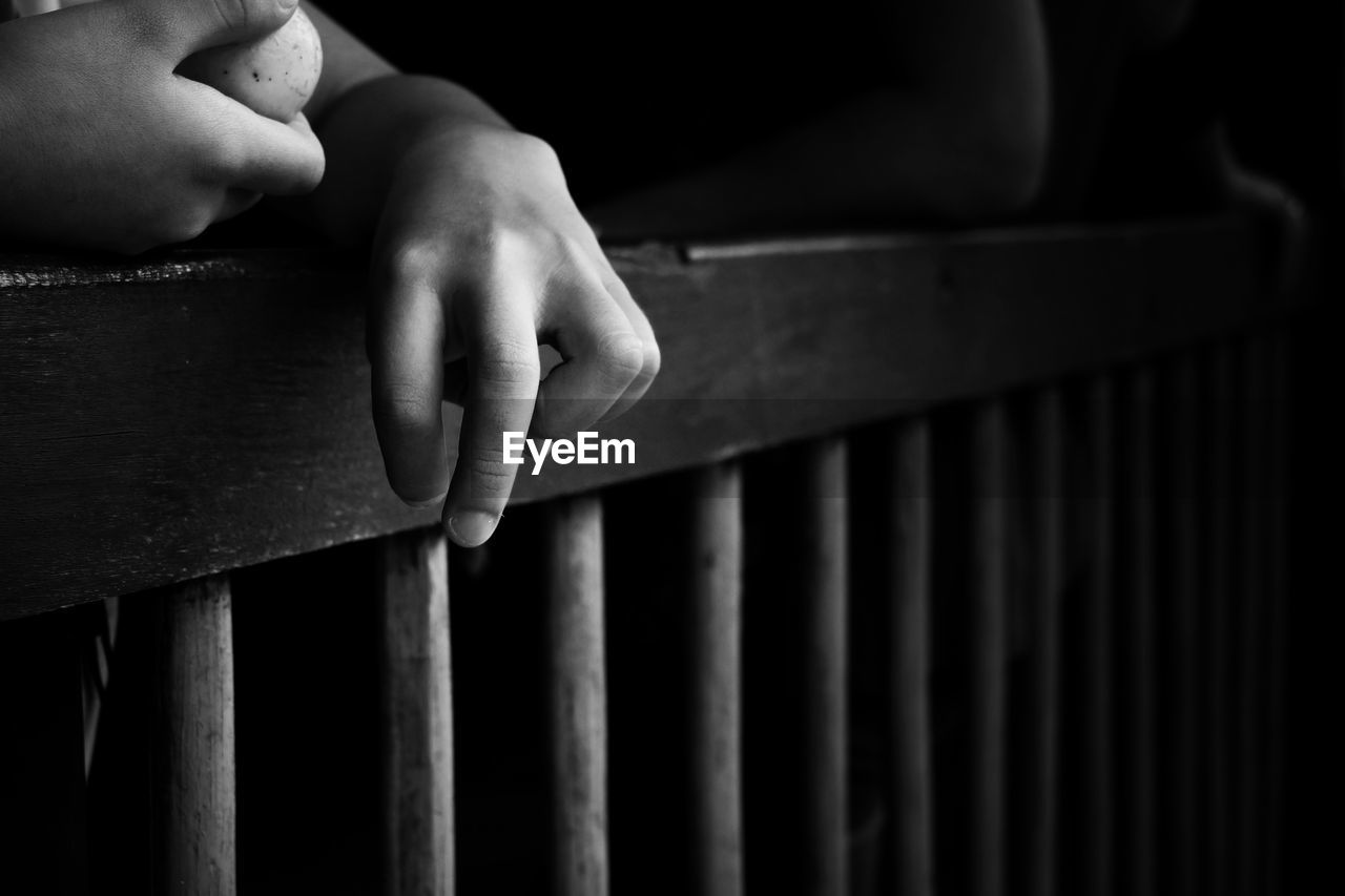 Close-up of hand of disabled child over railing