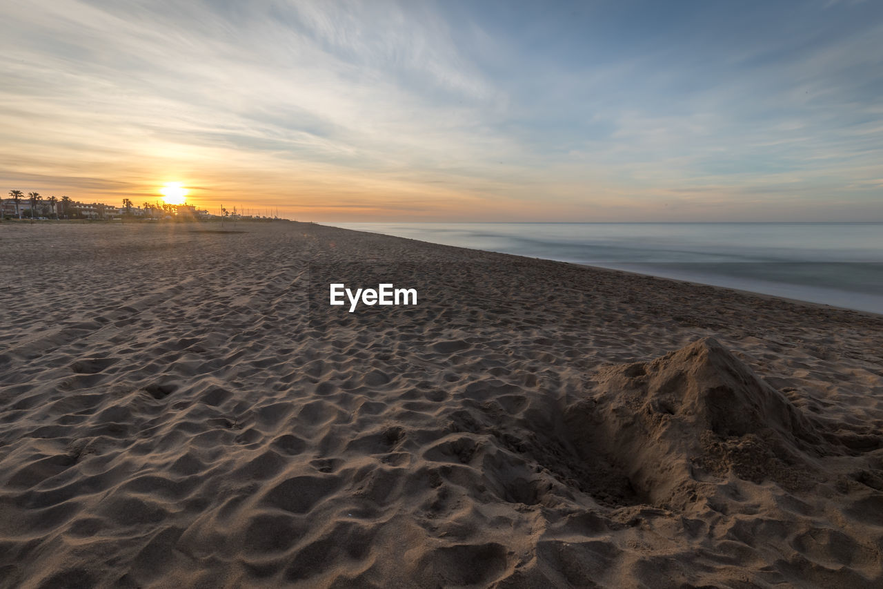 Scenic view of beach against sky during dawn