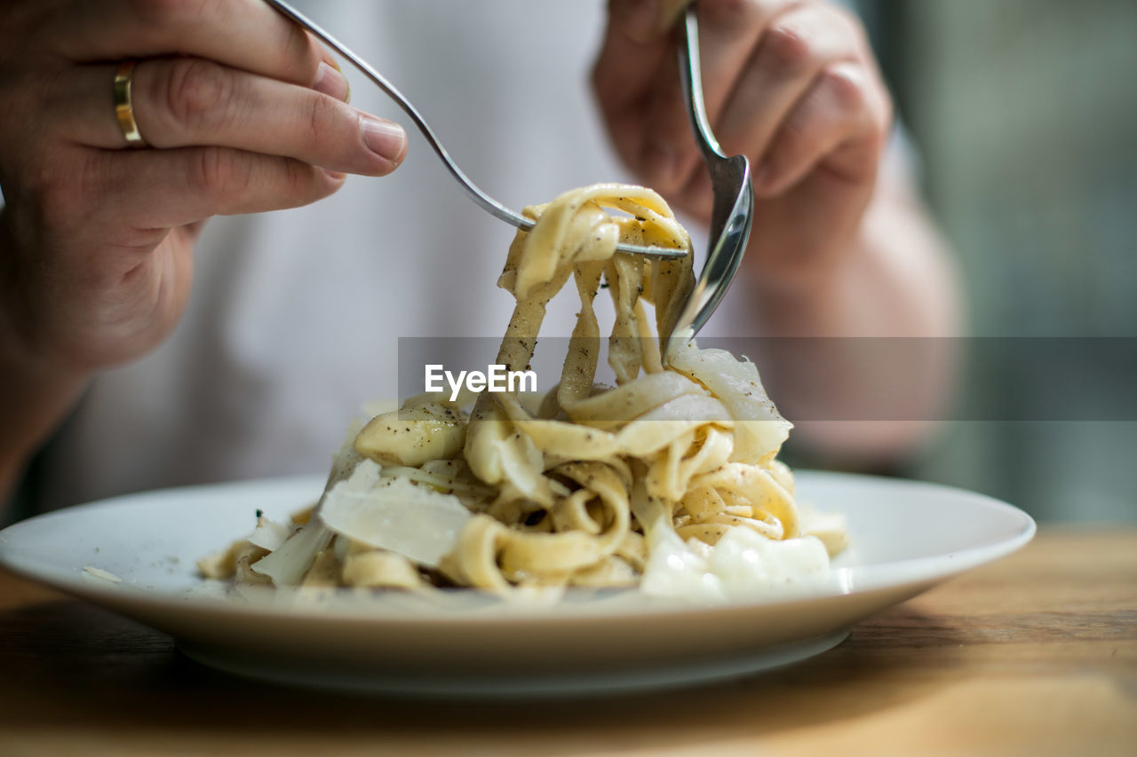 Close-up of man eating pasta in bowl