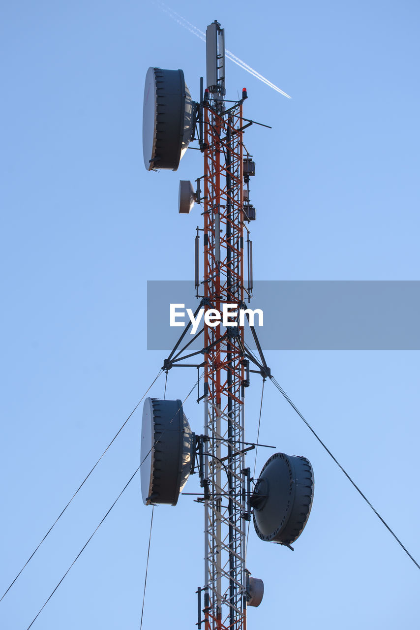low angle view of communications tower against clear blue sky