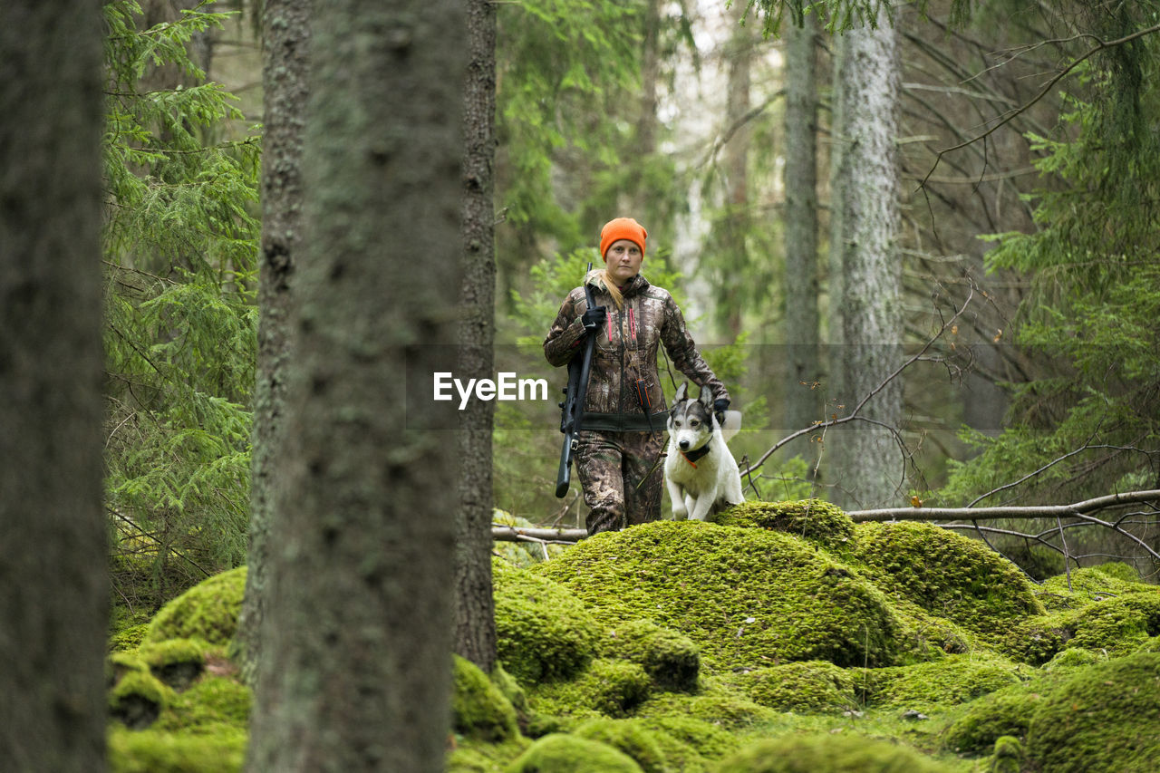 Woman with hunting dog in forest