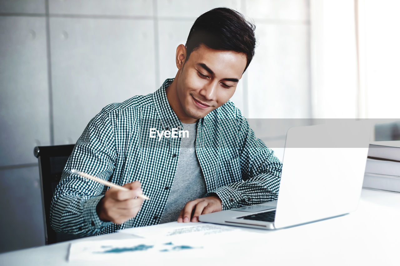 Businessman writing on paper in office