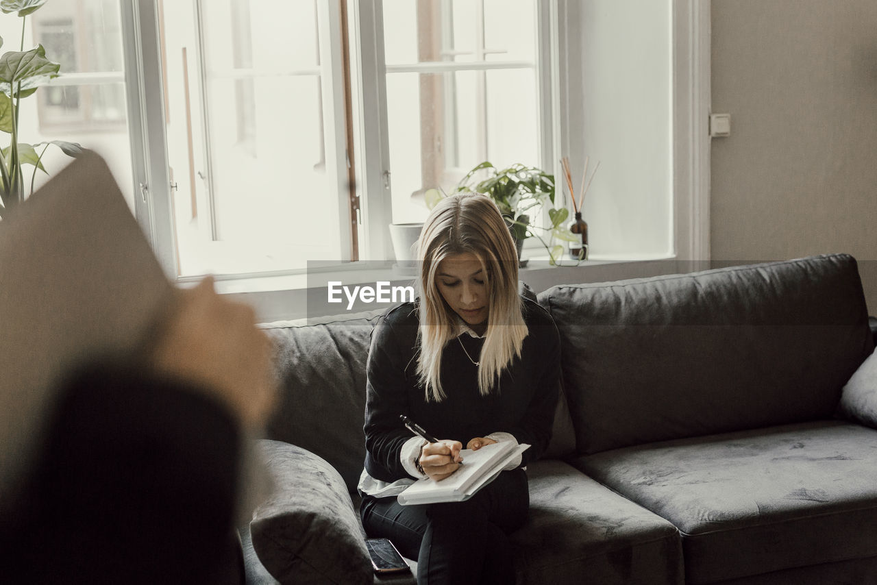 Woman taking notes during work meeting