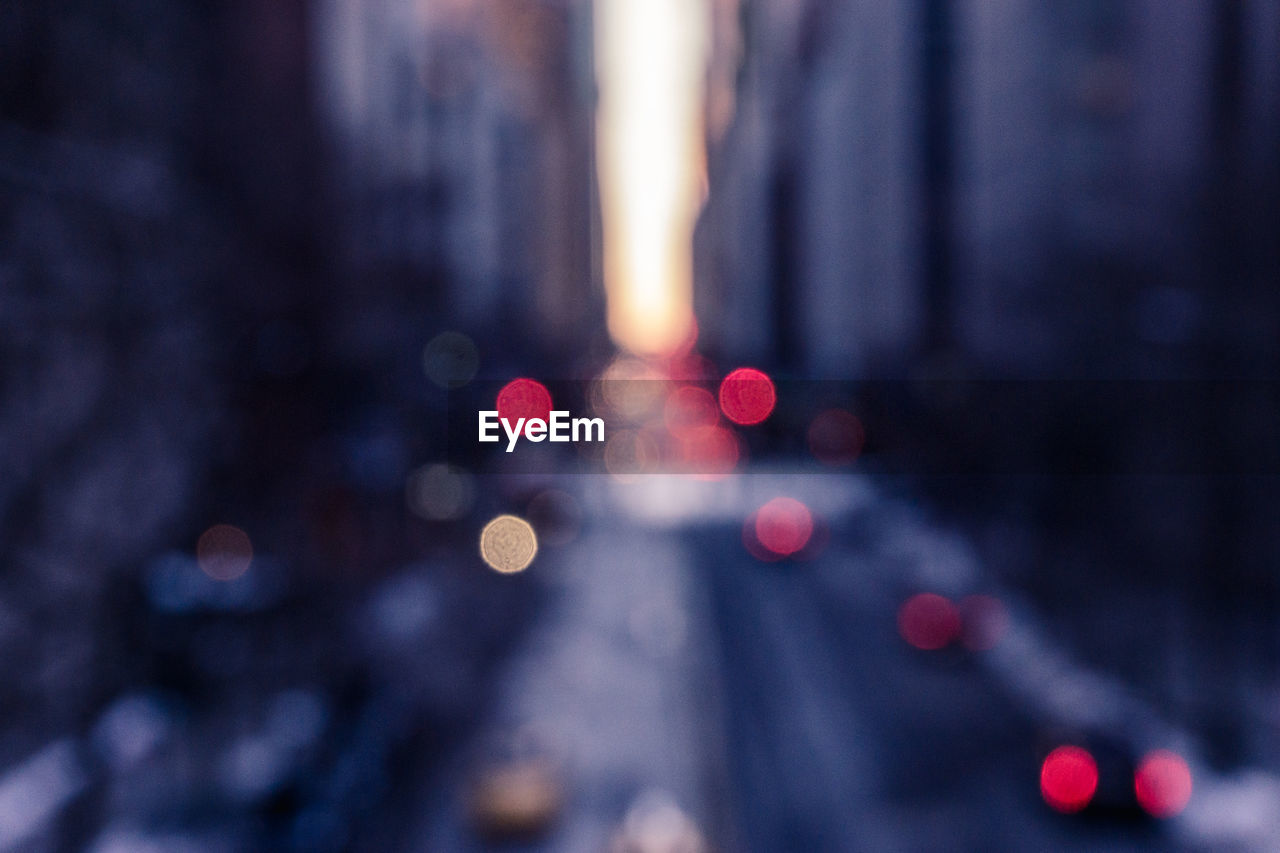 Defocused image of lights on street amidst buildings