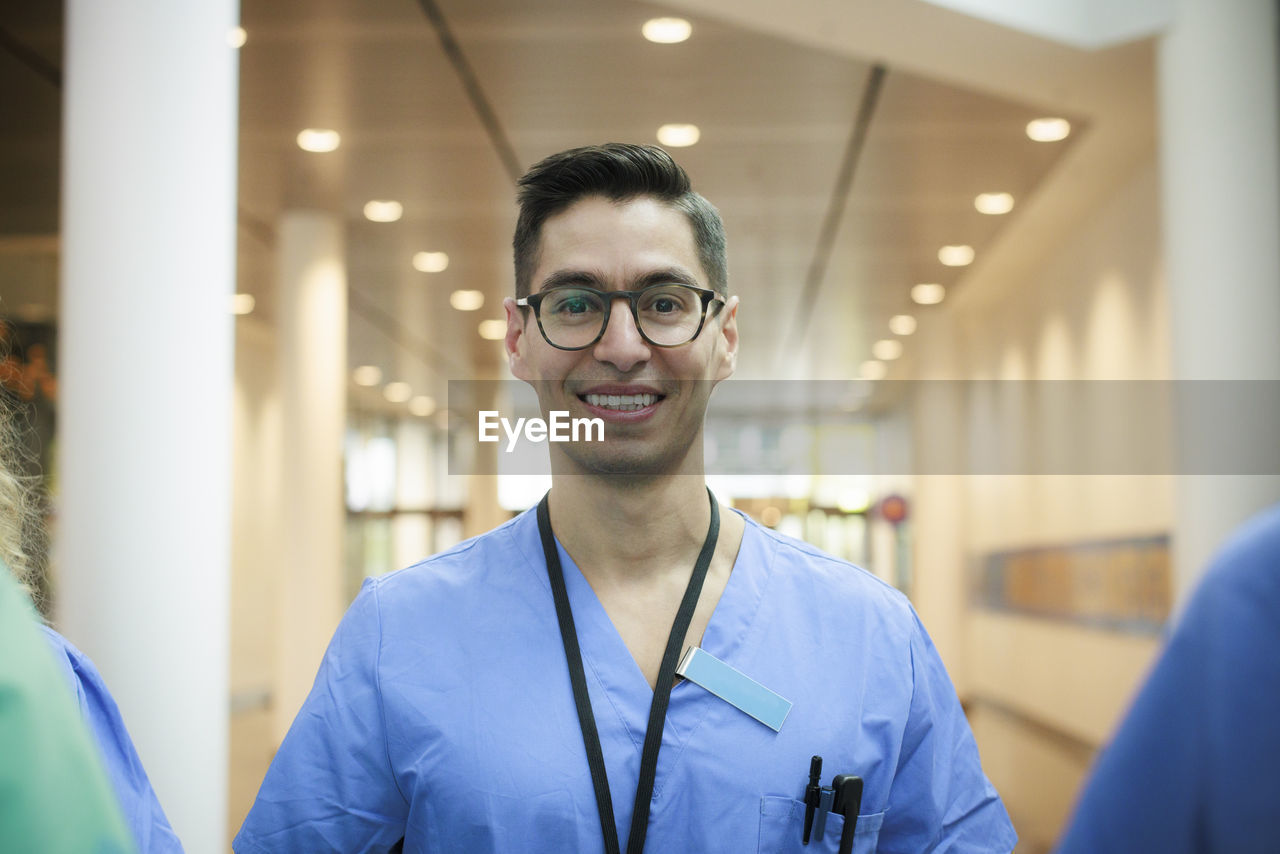 Portrait of happy male healthcare staff wearing eyeglasses at hospital