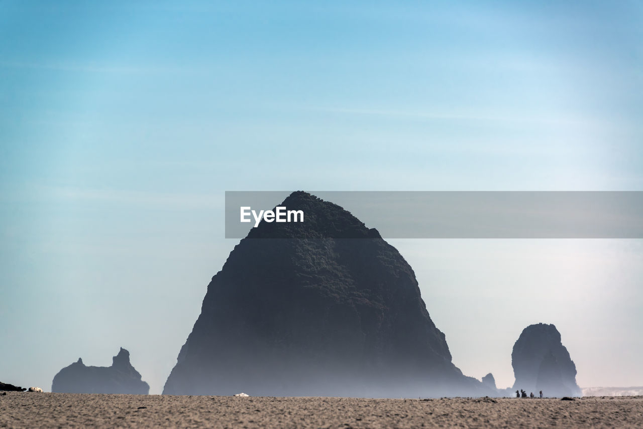 Rock formations on beach against sky