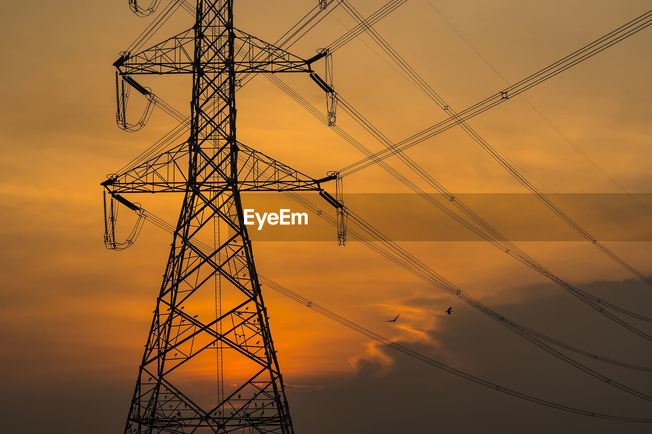 electricity, technology, power generation, power supply, electricity pylon, cable, sky, sunset, silhouette, transmission tower, overhead power line, tower, nature, architecture, built structure, electrical supply, industry, power line, line, no people, alloy, environment, steel, high voltage sign, cloud, metal, grid, outdoor structure, communication, outdoors, business finance and industry, public utility, electrical grid, mast, twilight, outdoor power equipment, sign, orange color, abstract, back lit, in a row, warning sign, dusk