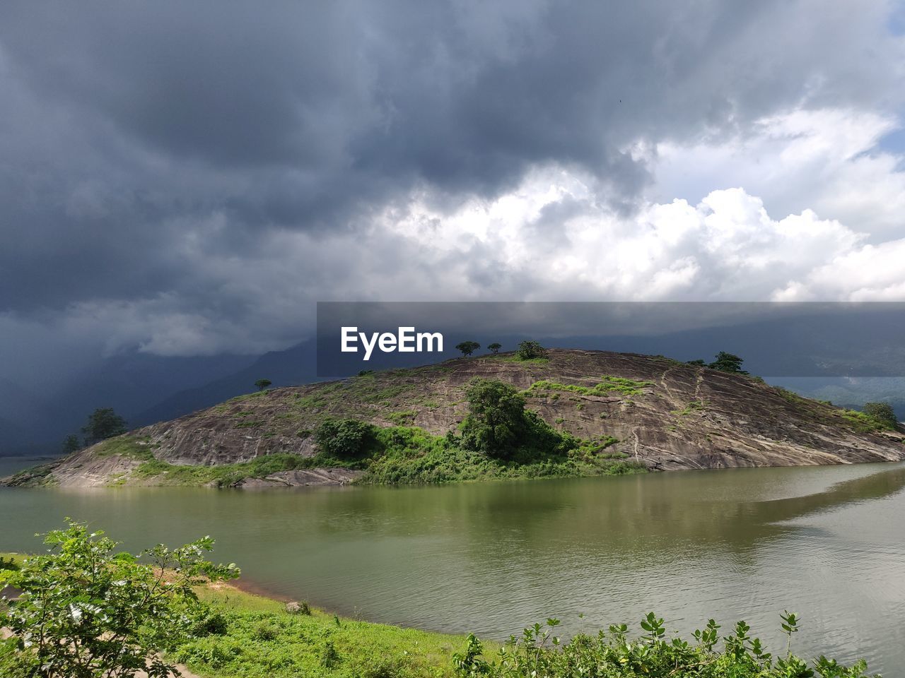 Scenic view of lake against cloudy sky