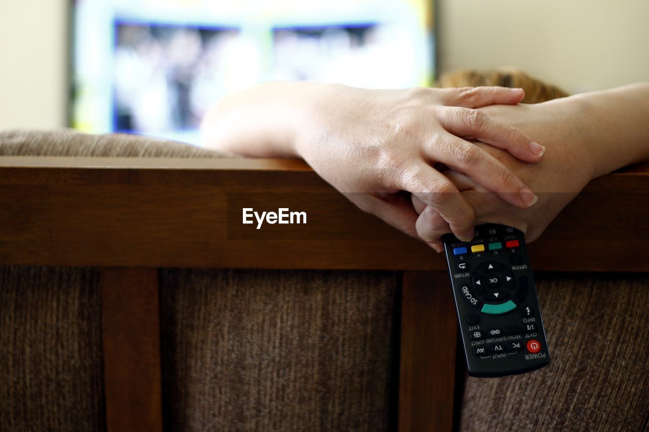 Woman holding remote while watching tv