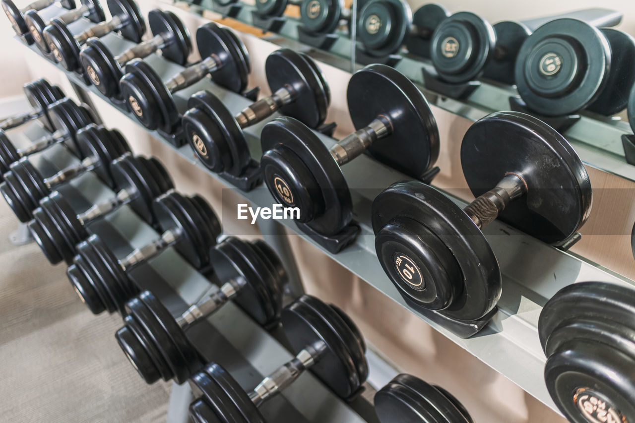 room, sport venue, dumbbell, indoors, in a row, gym, exercising, exercise equipment, large group of objects, no people, sports training, technology, rack, weight, equipment