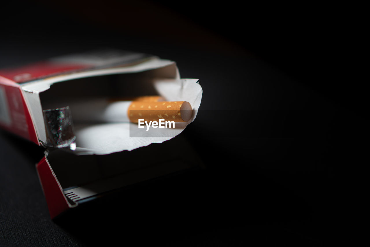 high angle view of hand holding book against black background