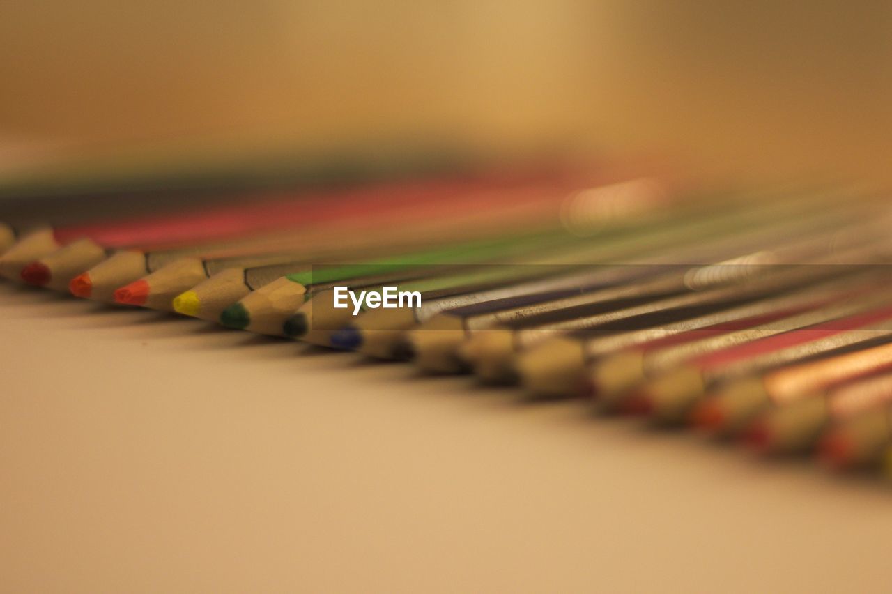 CLOSE-UP OF MULTI COLORED PENCILS IN SHELF