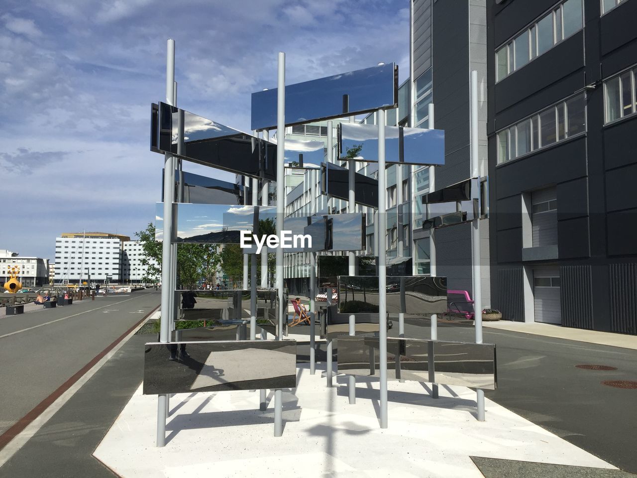 EMPTY ROAD BY BUILDING AGAINST SKY