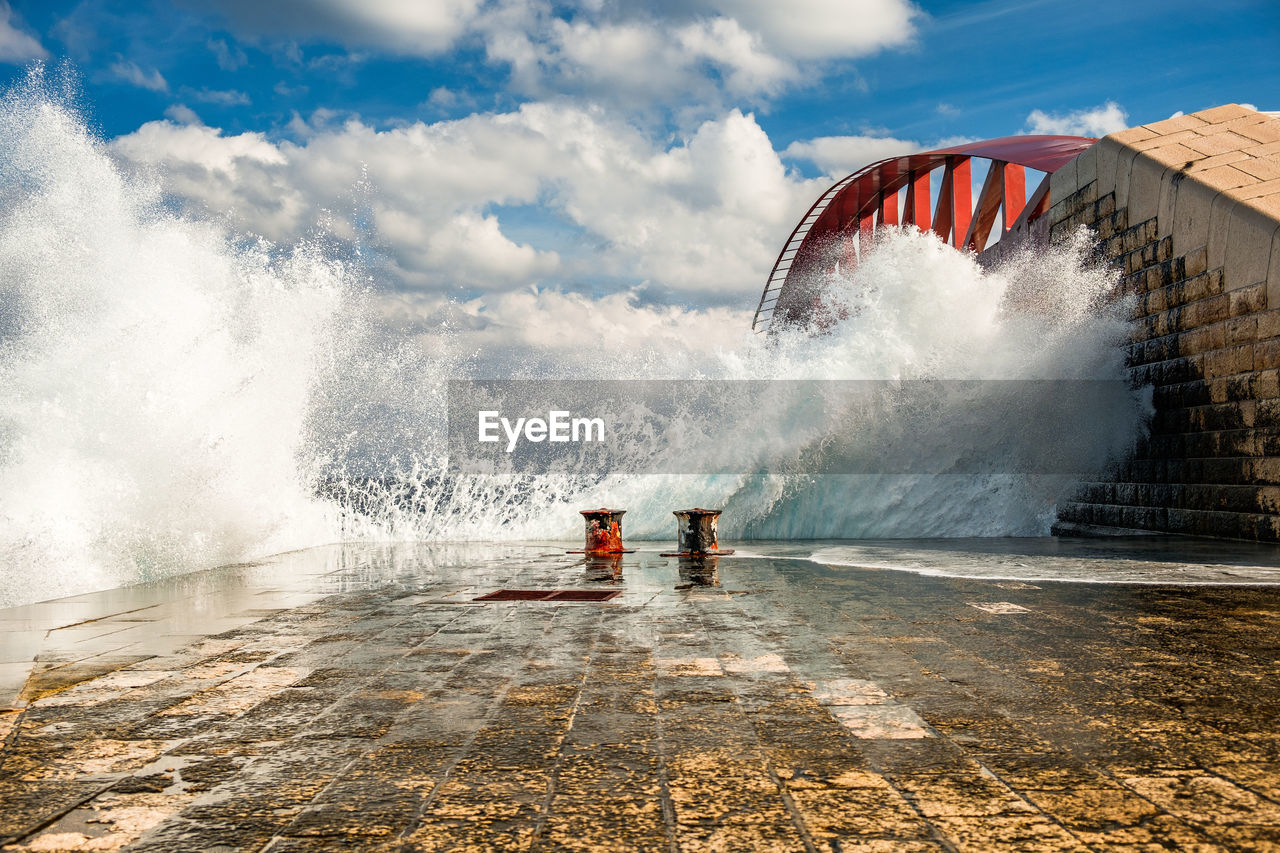 Water splashing in sea against sky