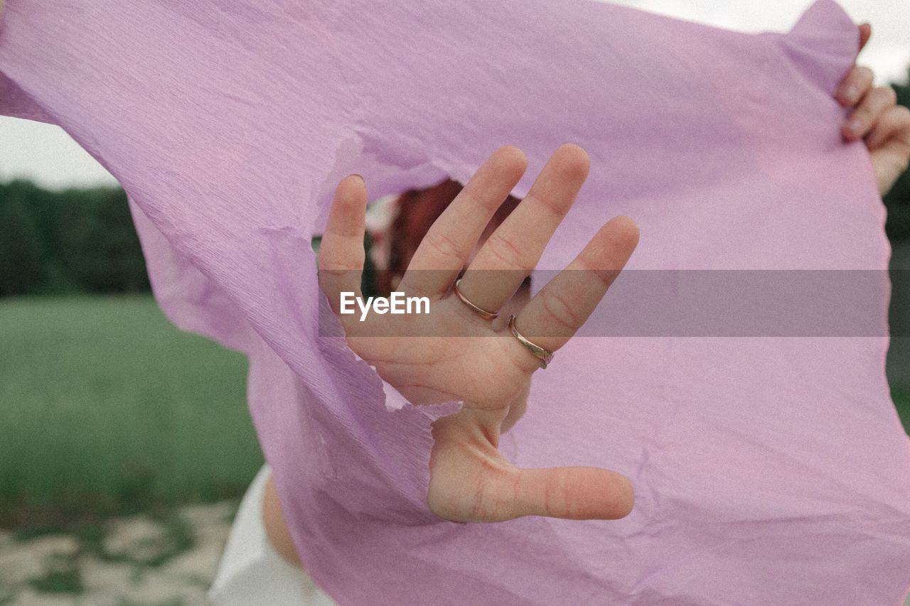 Cropped hand of woman holding torn paper