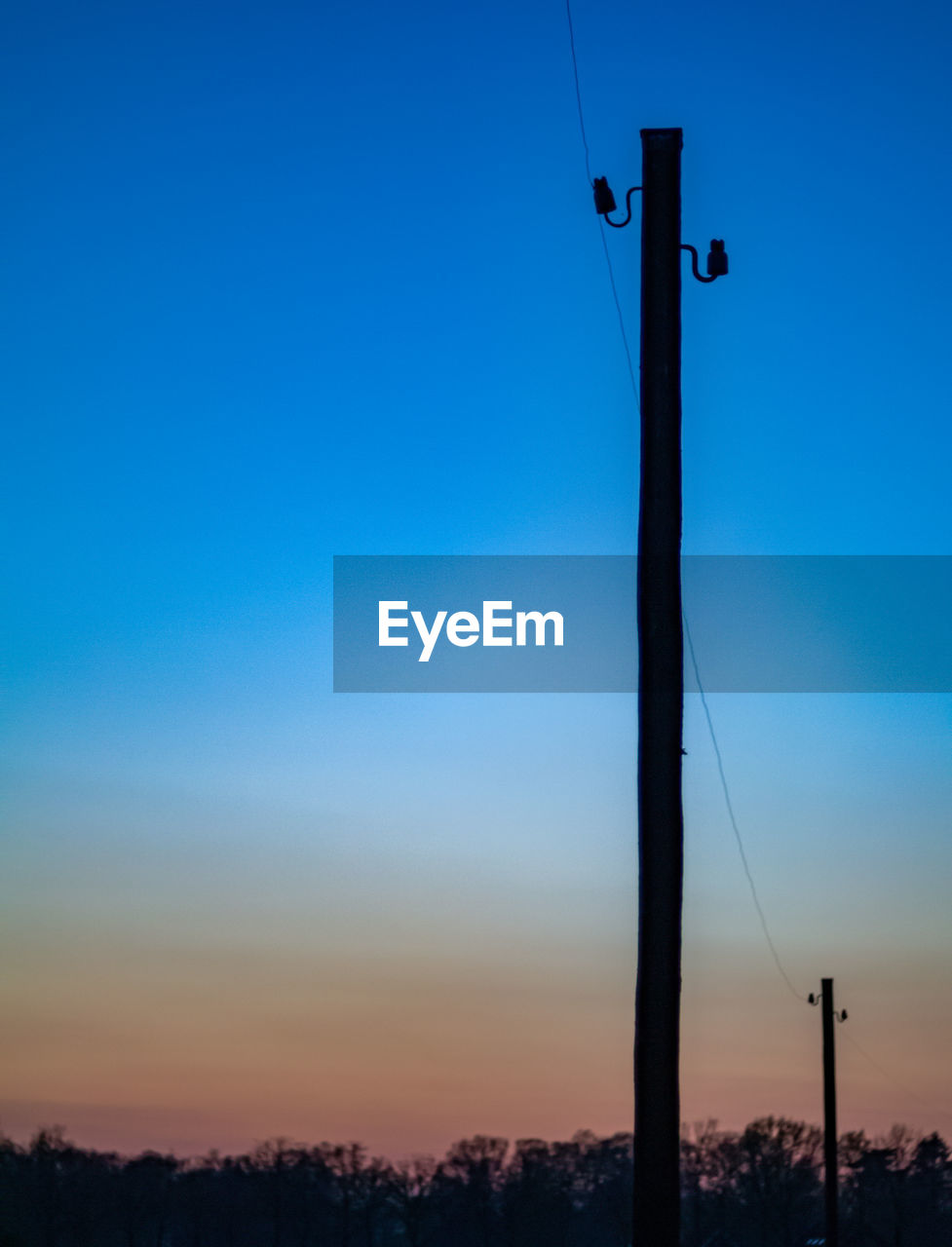 LOW ANGLE VIEW OF SILHOUETTE POLE AGAINST CLEAR BLUE SKY