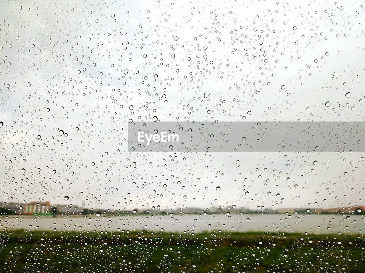 RAINDROPS ON SKY SEEN THROUGH WET WINDSHIELD