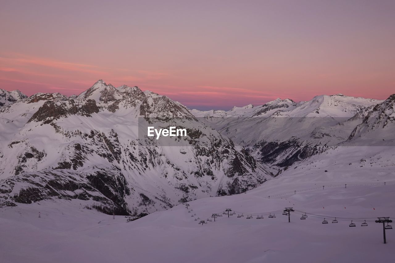 Scenic view of snowcapped mountains against sky during sunset