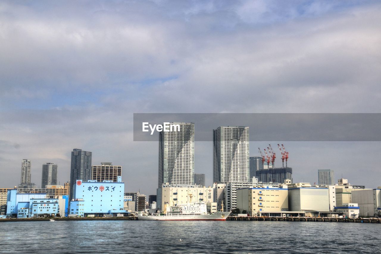 VIEW OF SKYSCRAPERS AT WATERFRONT